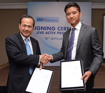 CEO & Managing Director of RHB Insurance Kong Shu Yin (left) exchanging document with CEO and Founder of BookDoc Datuk Chevy Beh