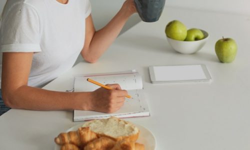 close-up-woman-planning-her-day-keeps-grey-cup-with-some-liquid_295783-372 Tips to overcome a weight-loss plateau - Track and Reassess your habit | BookDoc