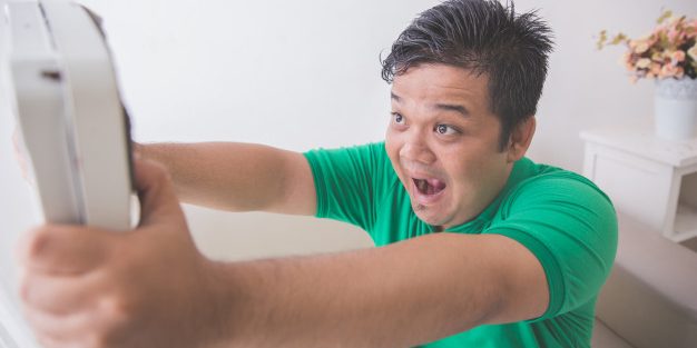 shocked-obese-man-while-looking-weight-scale_8595-272 Tips To Overcome A Weight-Loss Plateau - a man frustrated with his weight | BookDoc