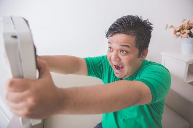 shocked-obese-man-while-looking-weight-scale_8595-272 Tips To Overcome A Weight-Loss Plateau - a man frustrated with his weight | BookDoc