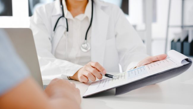 young-asia-female-doctor-white-medical-uniform-using-clipboard-is-delivering-great-news-talk-discuss-results (1) Health articles | health screening results | doctor consultation to patients | BookDoc